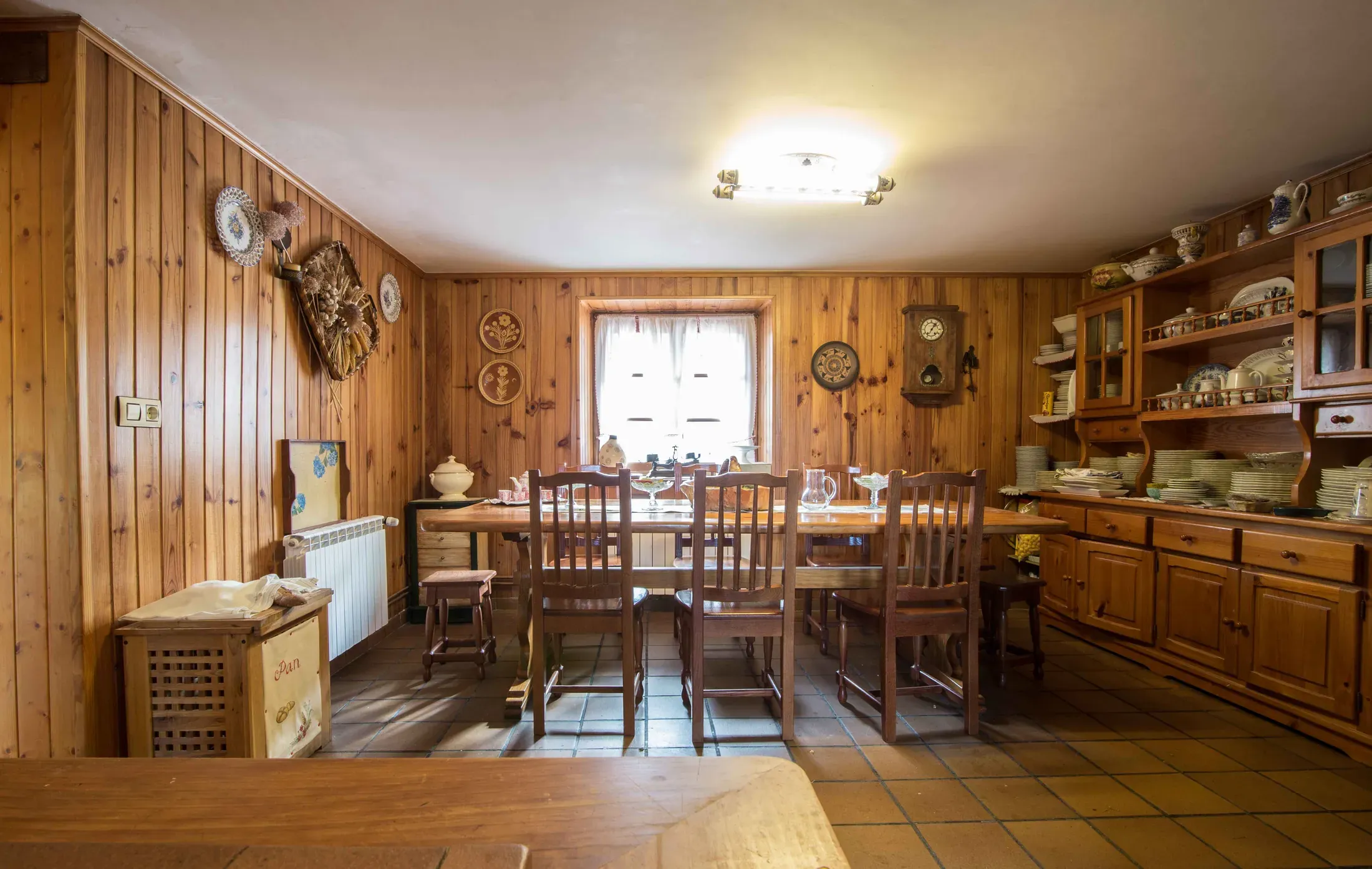 Comedor con paredes de madera, mesa amplia y aparadores