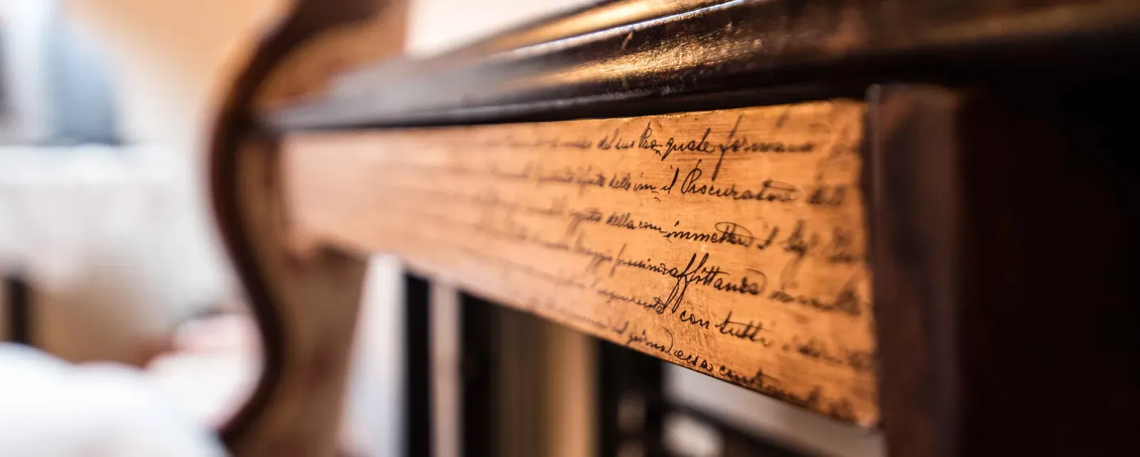 Detalle del respaldo de una silla de madera con inscripción manuscrita