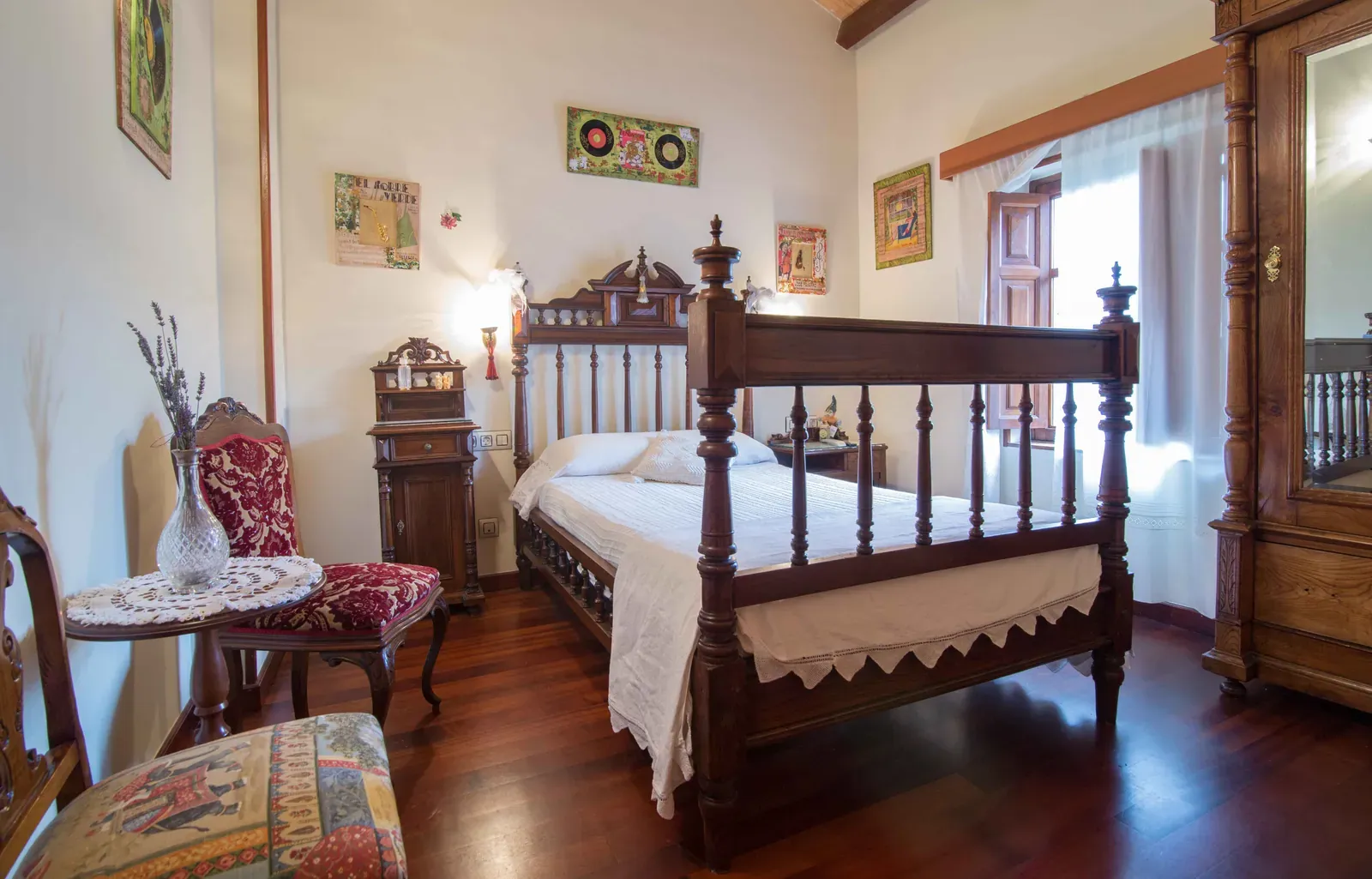 Habitación con cama de madera tallada y tocador con espejo
